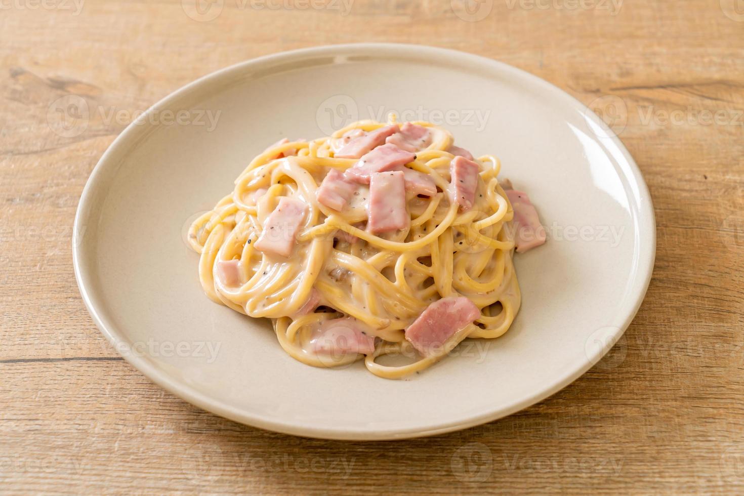 Espaguetis caseros con salsa de crema blanca con jamón - estilo de comida italiana foto