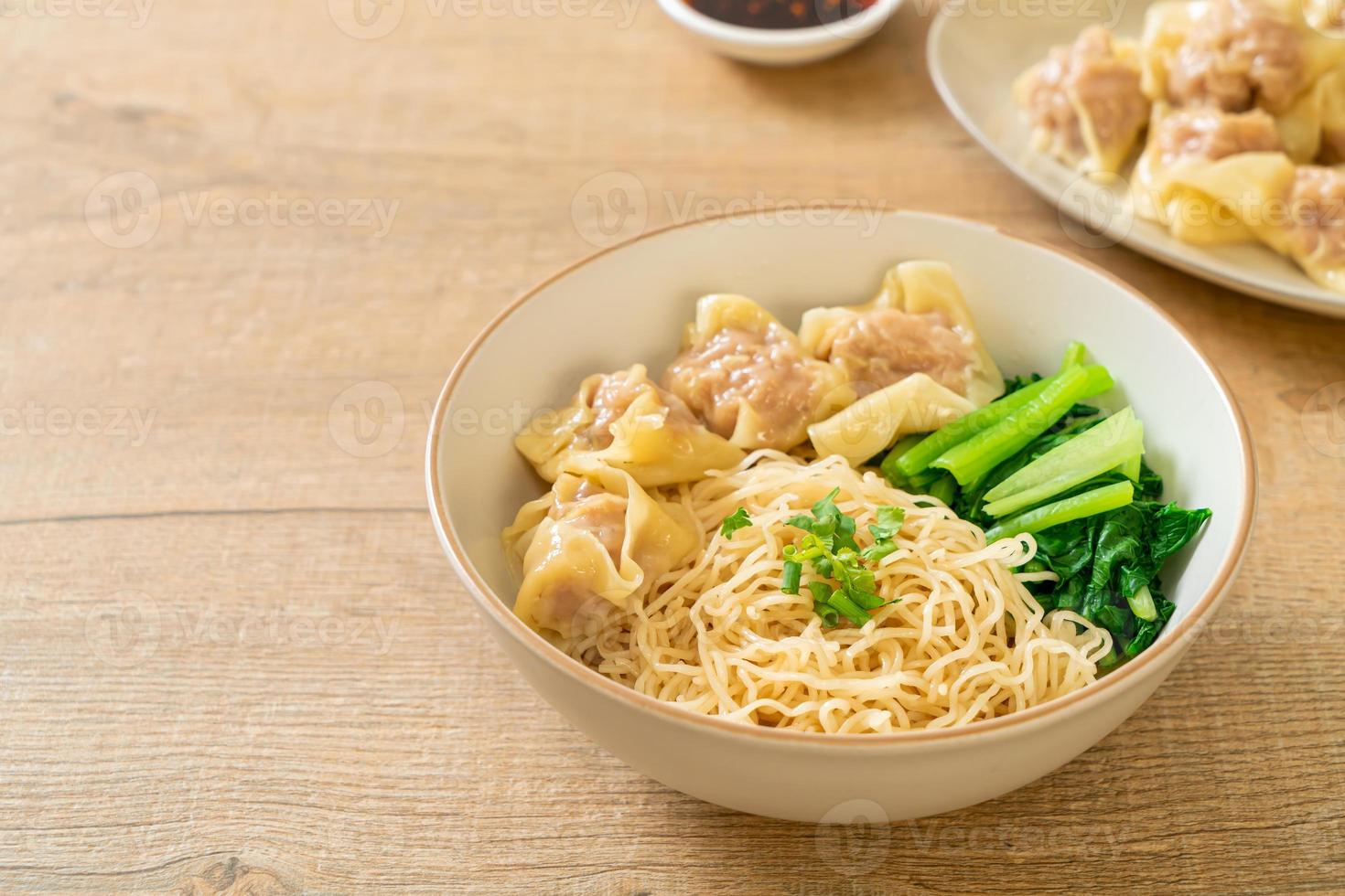 fideos de huevo secos con wonton de cerdo o albóndigas de cerdo sin sopa estilo asiático foto