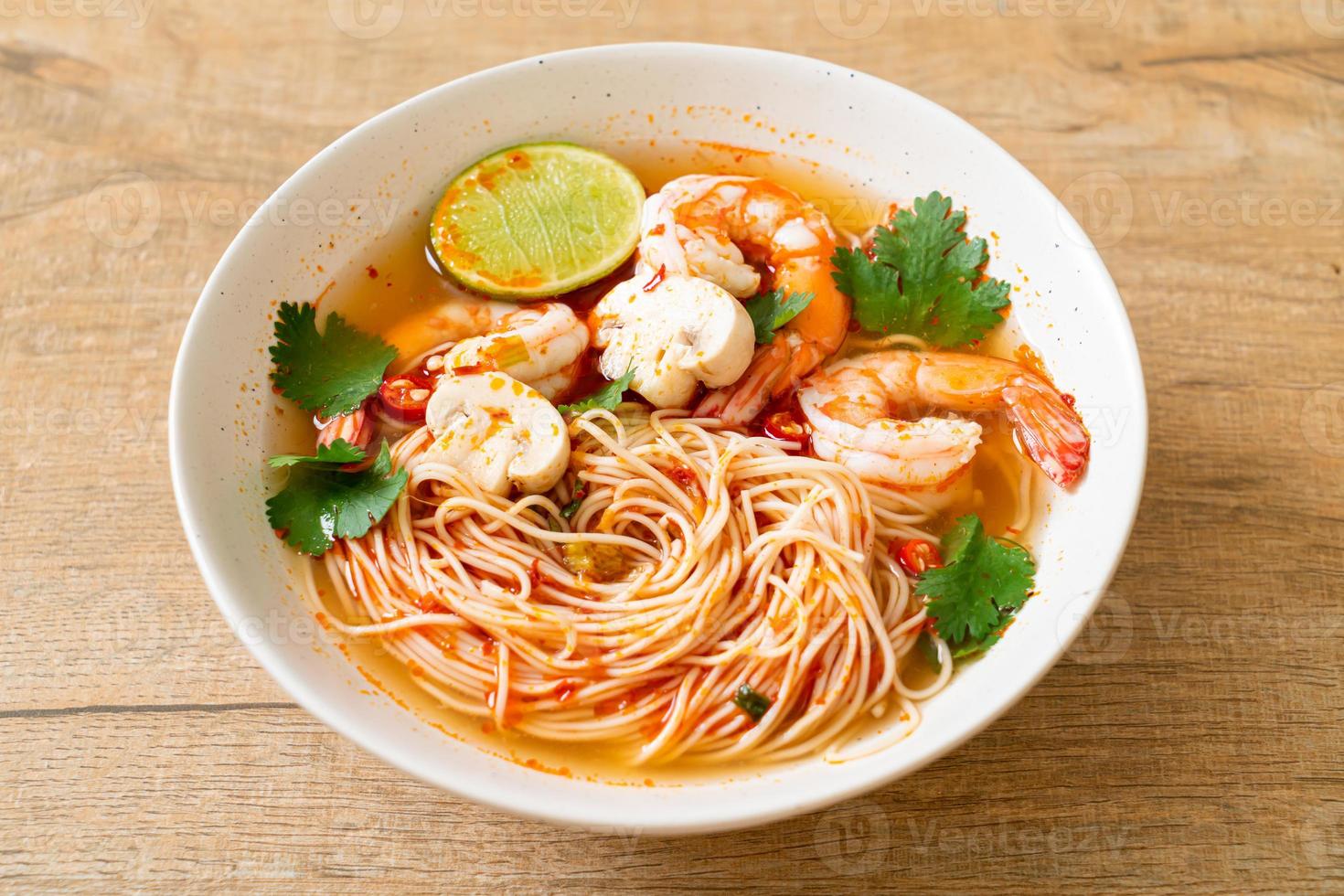 Noodles with spicy soup and shrimps in white bowl - Tom Yum Kung  - Asian food style photo