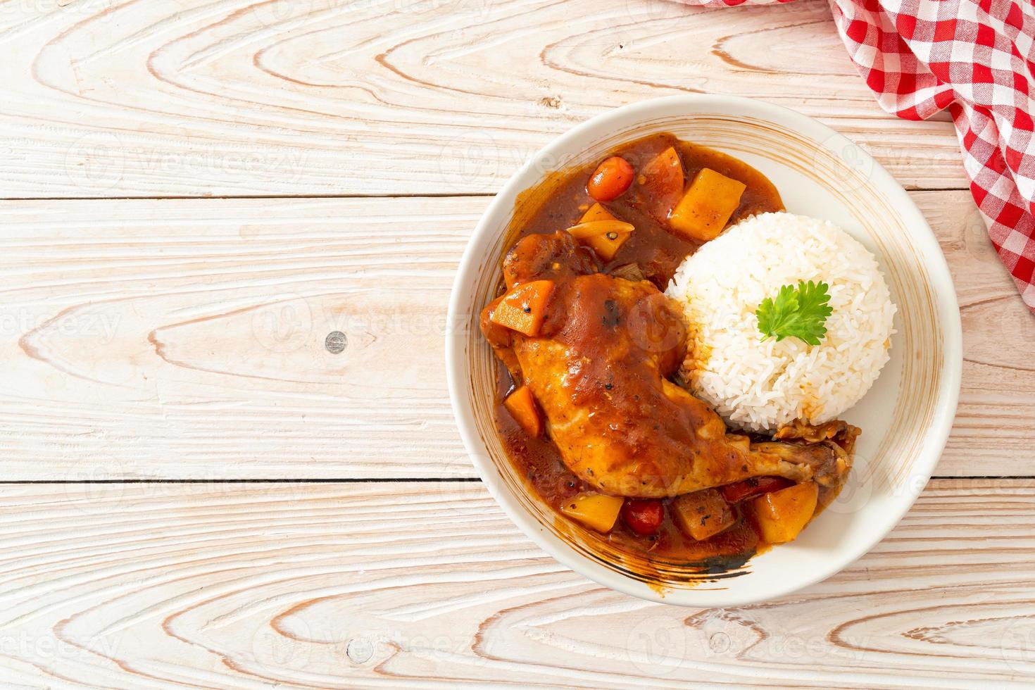 Homemade chicken stew with tomatoes, onions, carrot, and potatoes on plate with rice photo