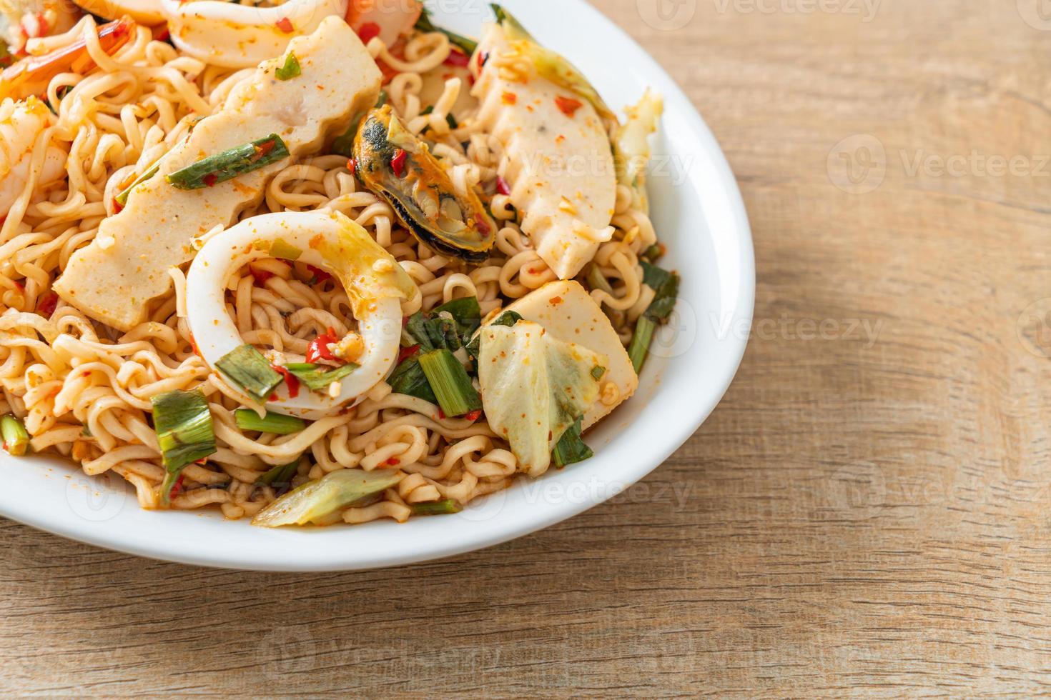 Ensalada picante de fideos instantáneos con carnes mixtas foto