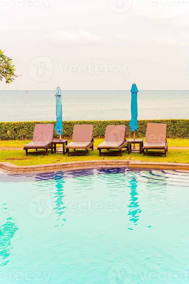 Chair pool or bed pool with umbrella around swimming pool photo