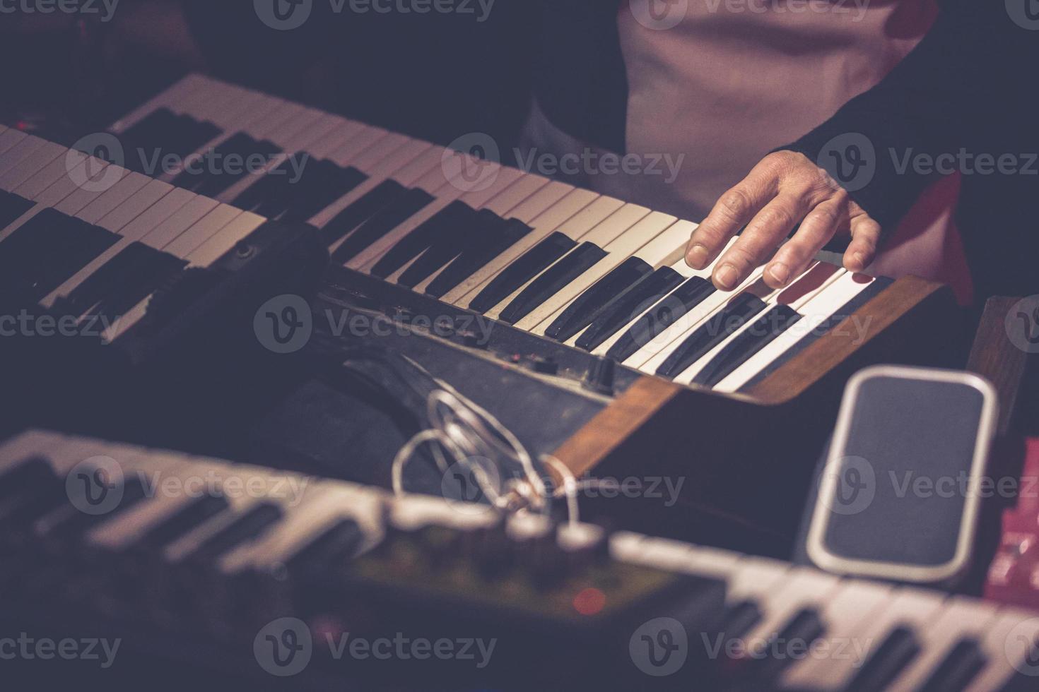 músico tocando un teclado de sintetizador vintage foto