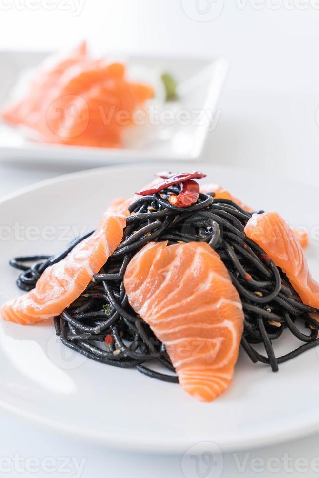 espaguetis negros picantes con salmón - estilo de comida fusión foto