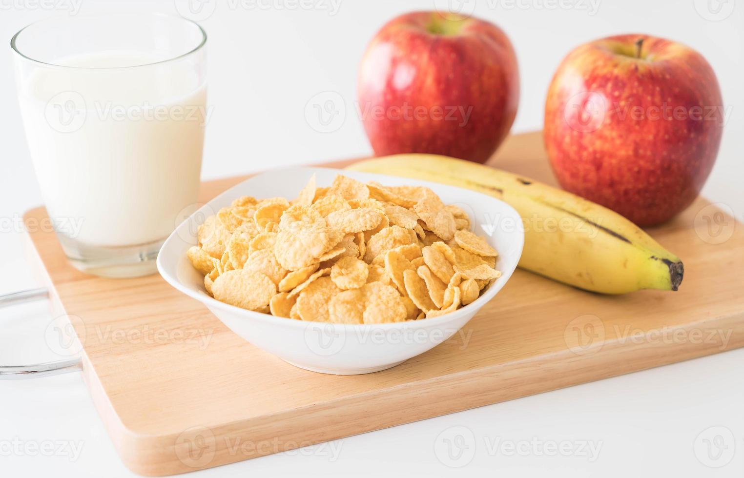 Milk, apple, banana, and cornflakes for breakfast photo