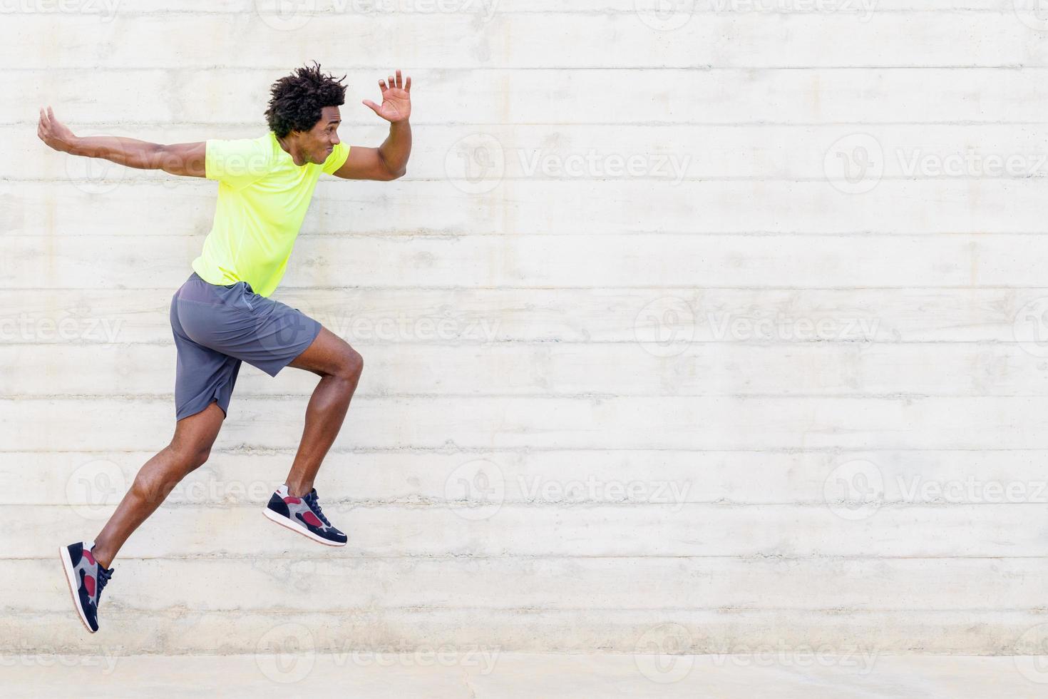 Black man training running jumps to strengthen his legs. photo