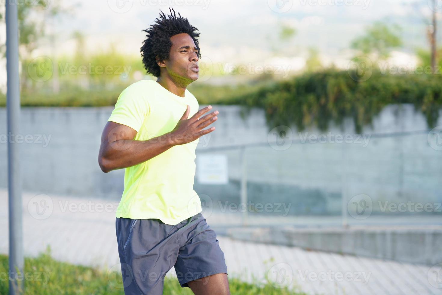 Black athletic man running in an urban park. photo