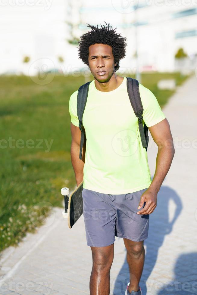 hombre negro va a hacer ejercicio en ropa deportiva y una patineta. 3015283  Foto de stock en Vecteezy