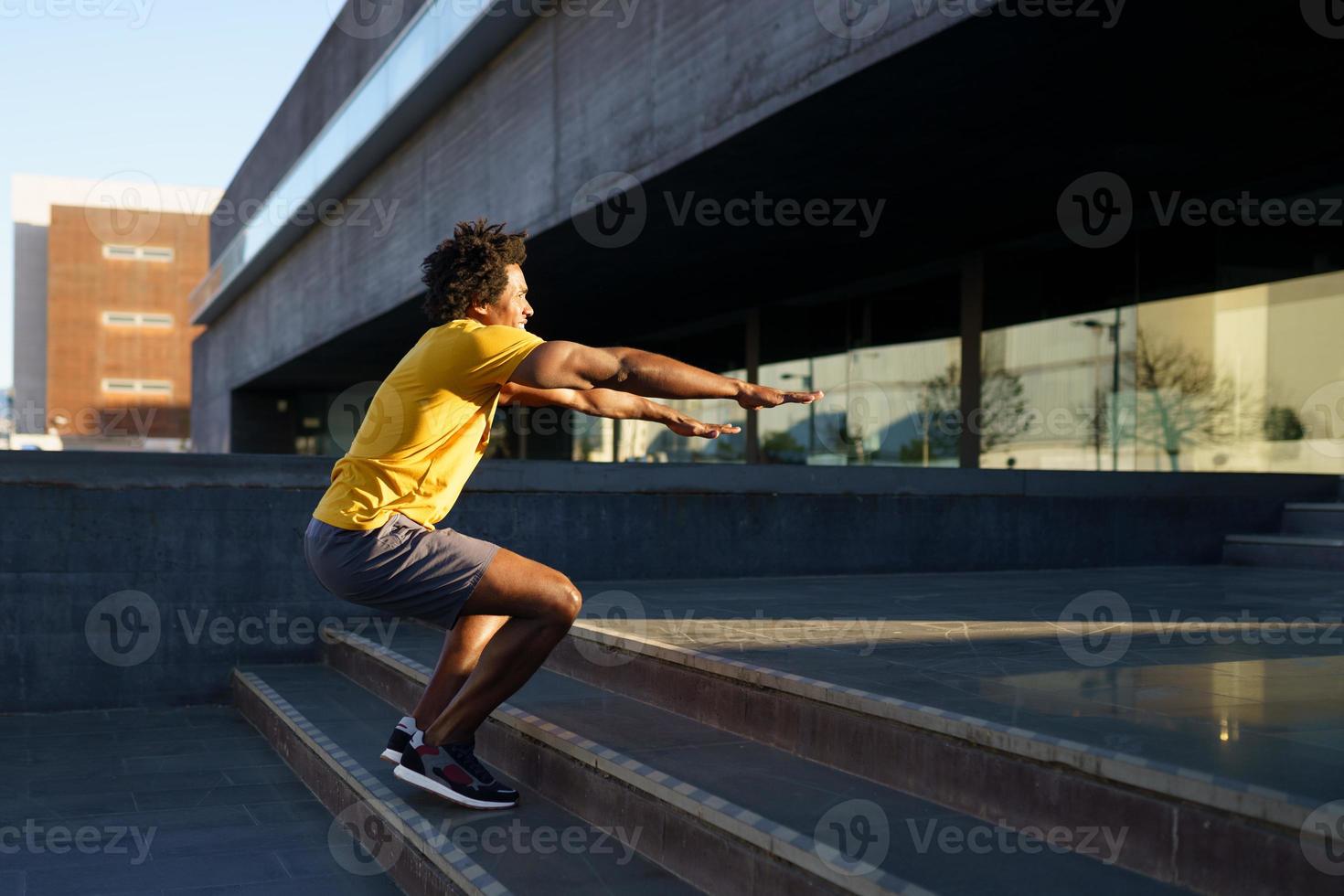 Black man doing squats with jumping on a step. photo