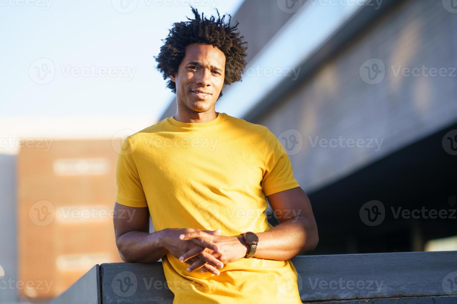 Black man with afro hair taking a break after workout. photo