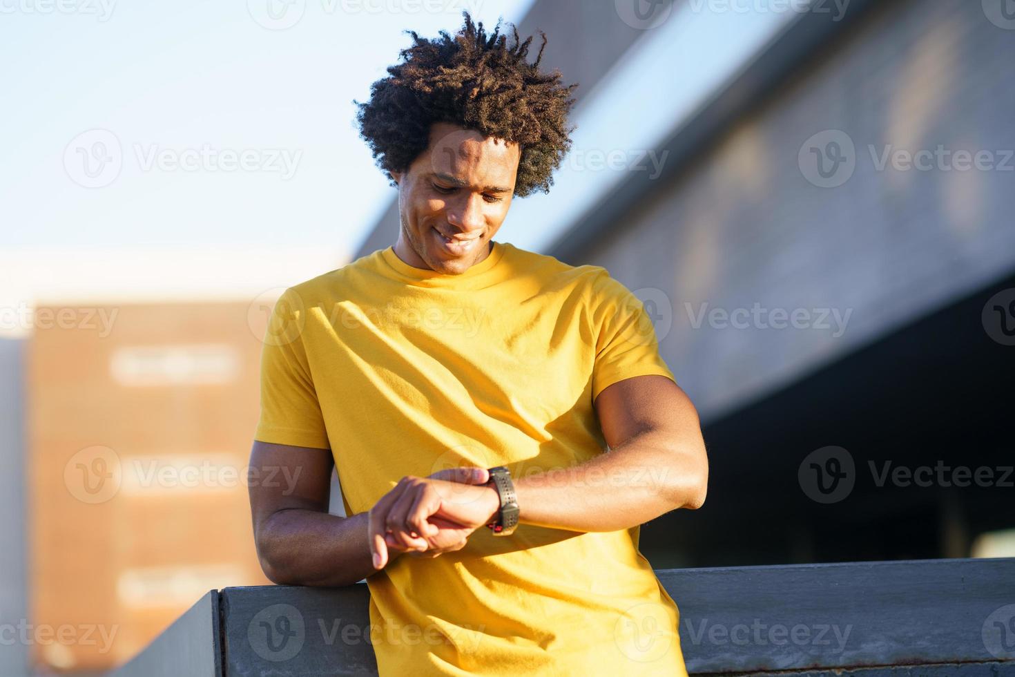 Black man consulting his smartwatch to view his training data. photo