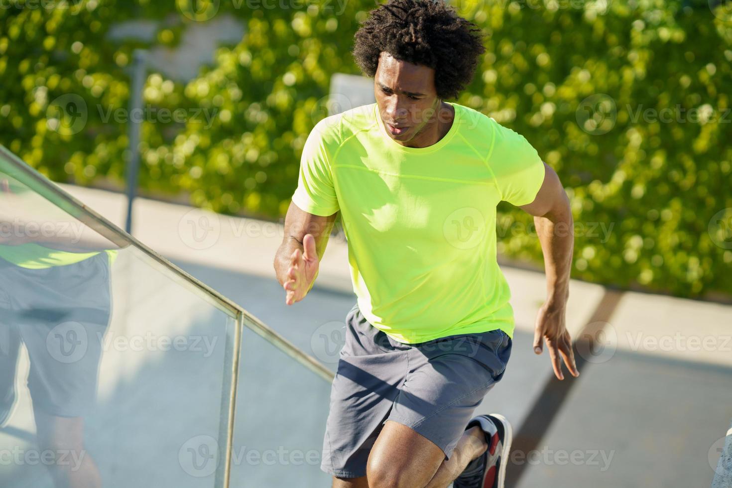 hombre negro corriendo arriba al aire libre. hombre joven haciendo ejercicio. foto