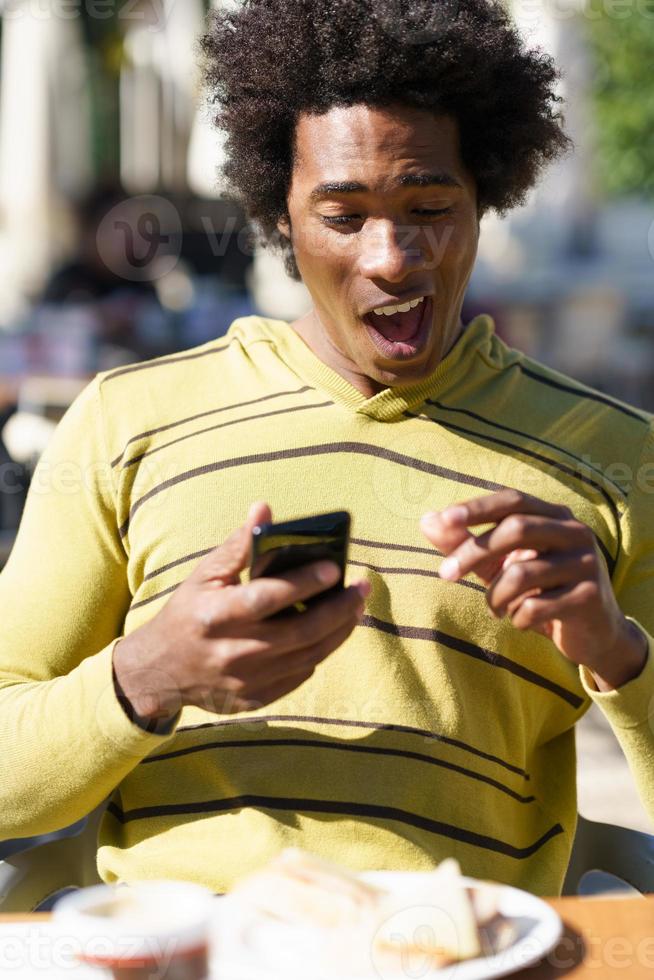 negro cubano tomando una foto con su teléfono inteligente a un refrigerio