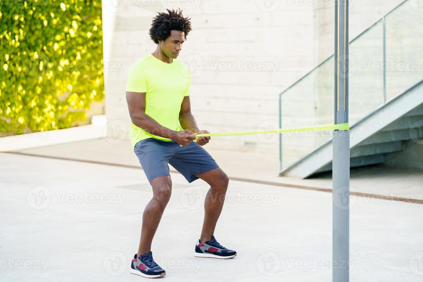 Black man working out with elastic band outdoors photo