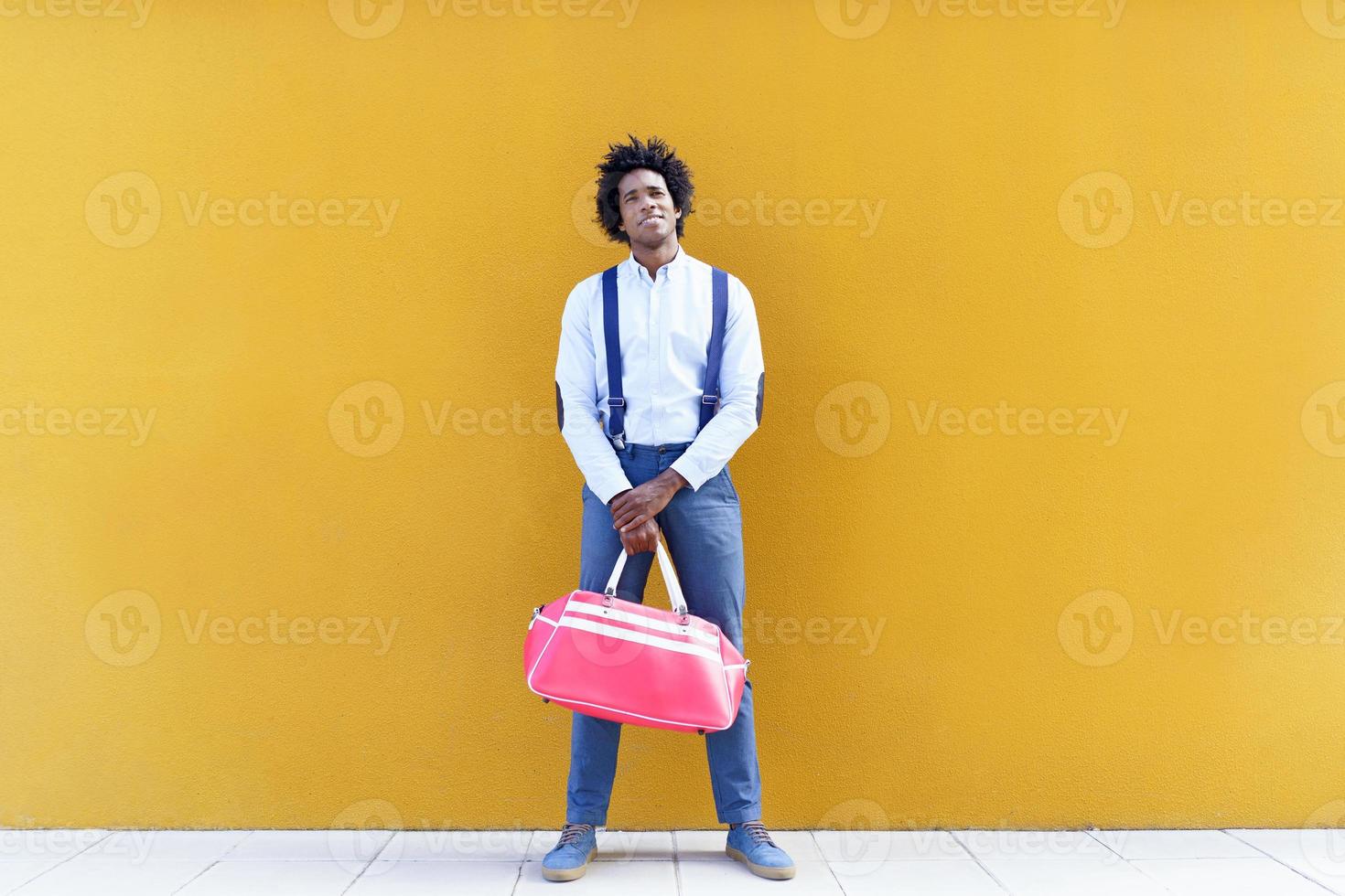 hombre negro con peinado afro que lleva una bolsa de deporte foto