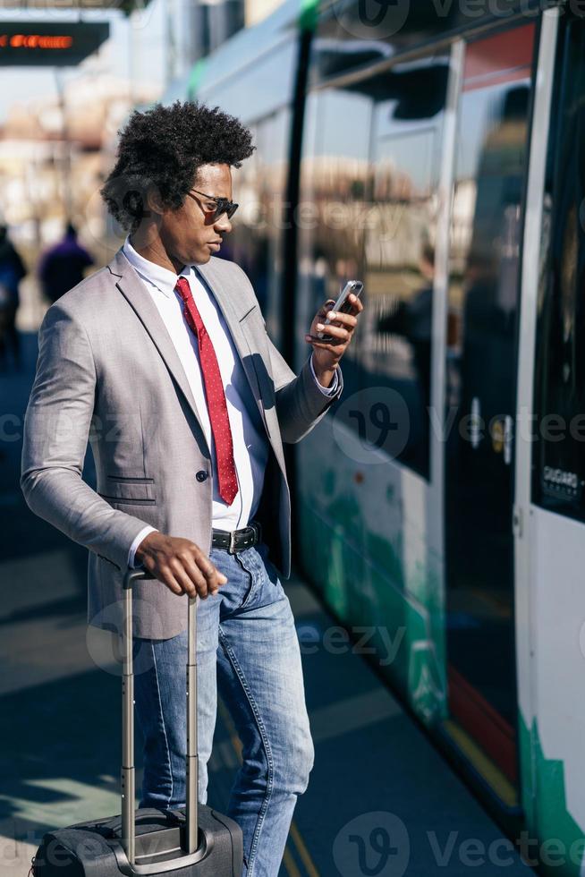 hombre de negocios negro esperando el próximo tren foto