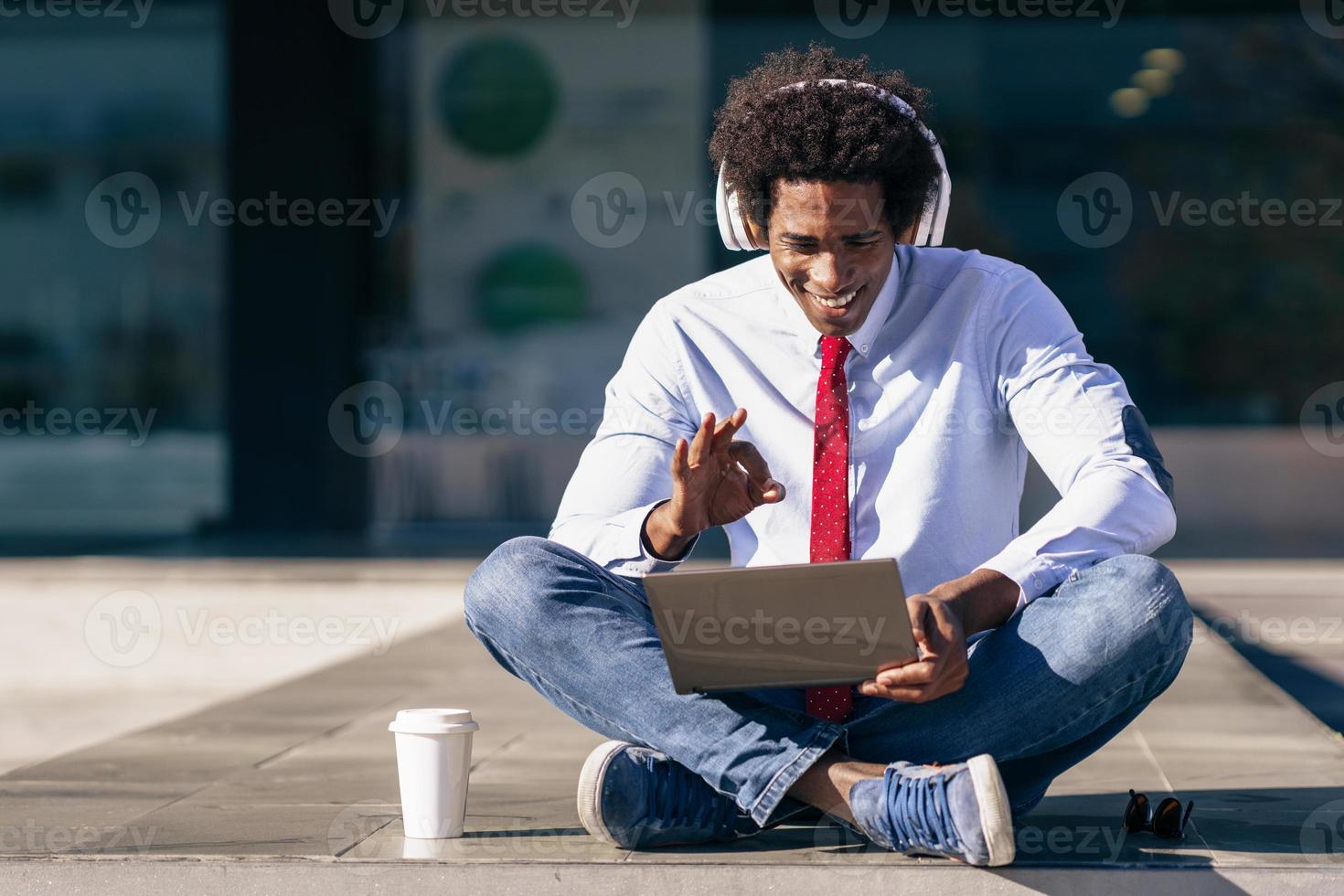 empresario negro con ordenador portátil y auriculares foto