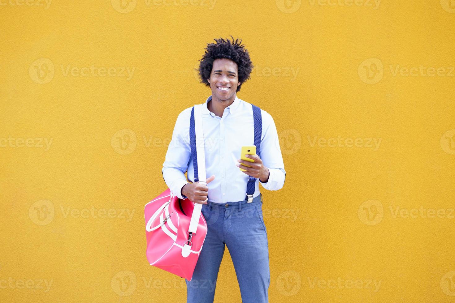 Black man with afro hairstyle carrying a sports bag photo