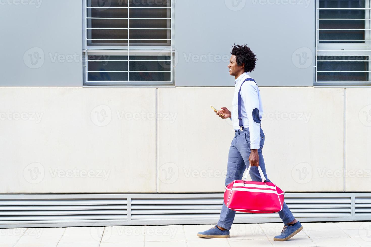 Black man with afro hairstyle carrying a sports bag photo