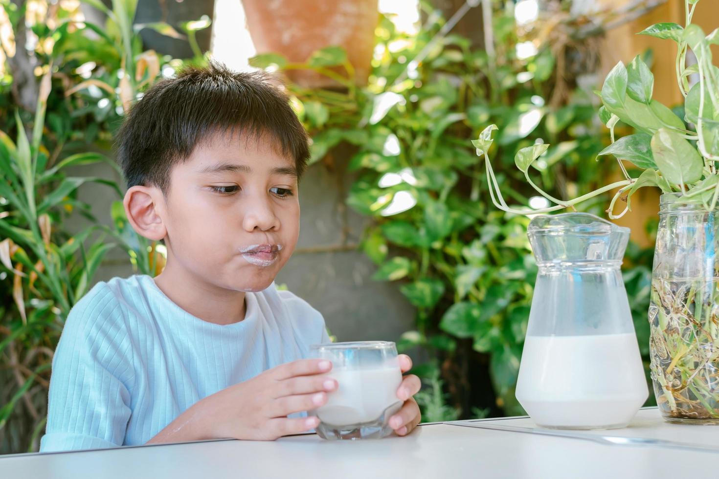 The boy's mouth was stained with milk stains after he drank the milk photo