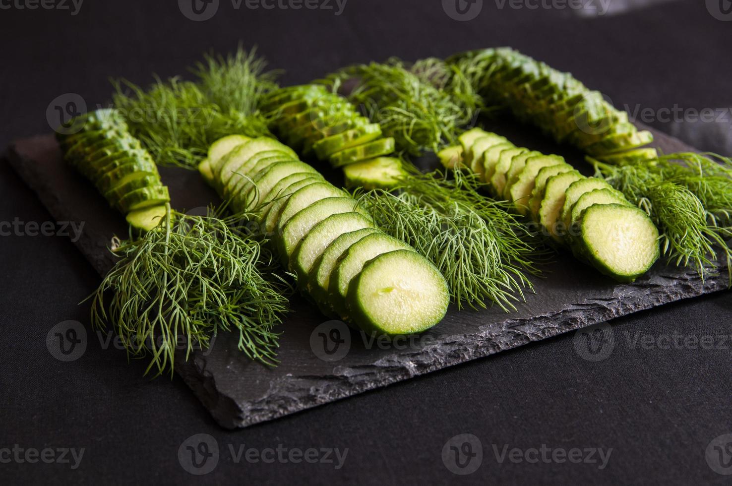 Natural fresh green cucumbers from a home garden on a black background photo