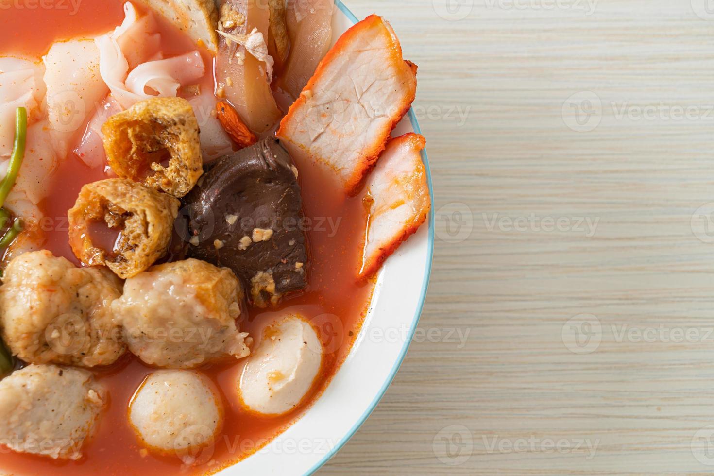 Noodles with meatballs in pink soup photo