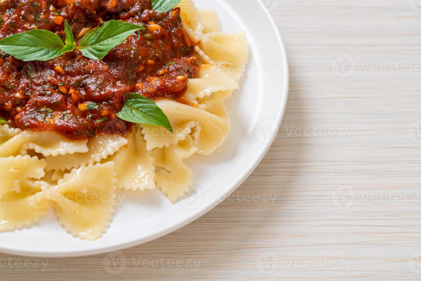 pasta farfalle con albahaca y ajo en salsa de tomate foto