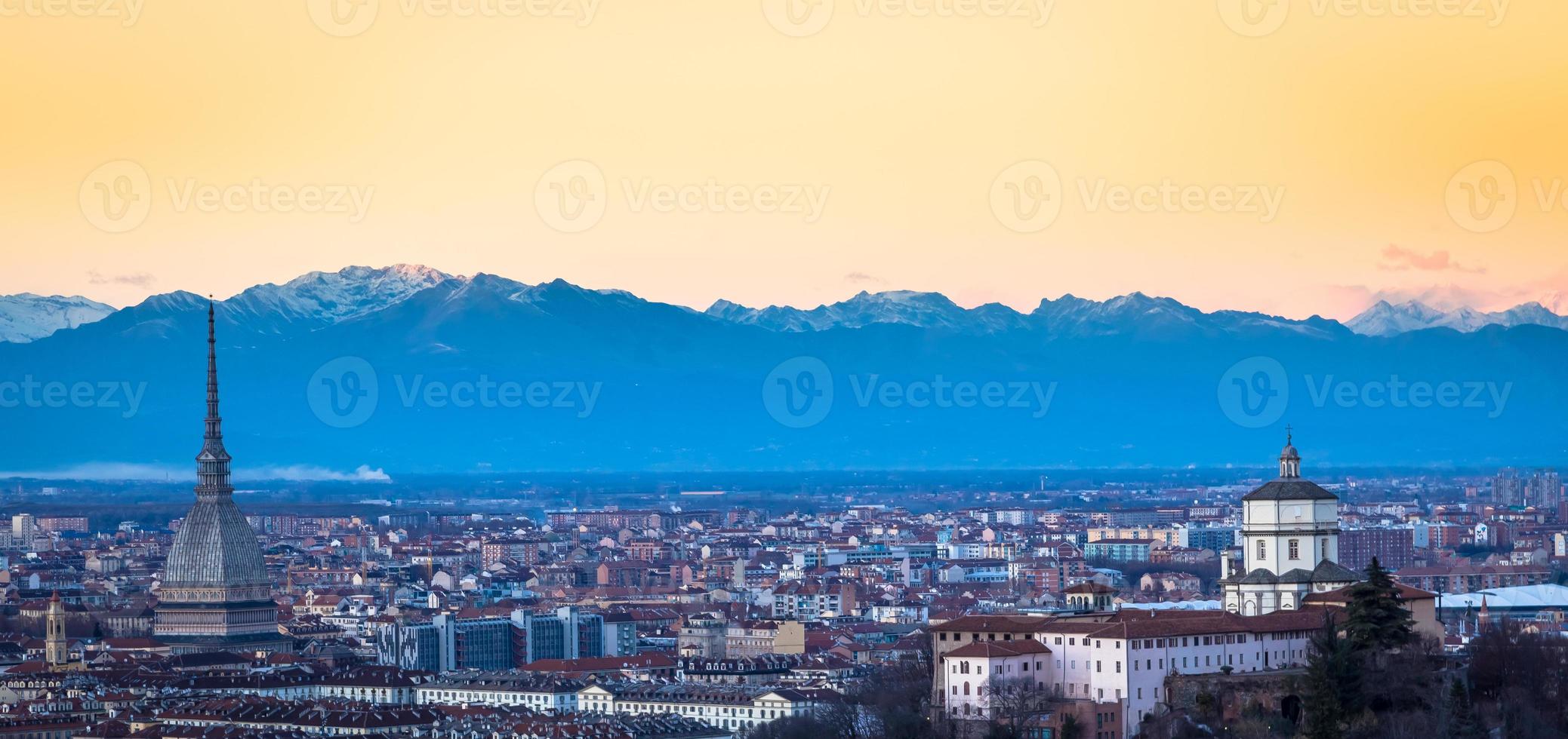 Horizonte panorámico de Turín al atardecer con los Alpes en segundo plano. foto