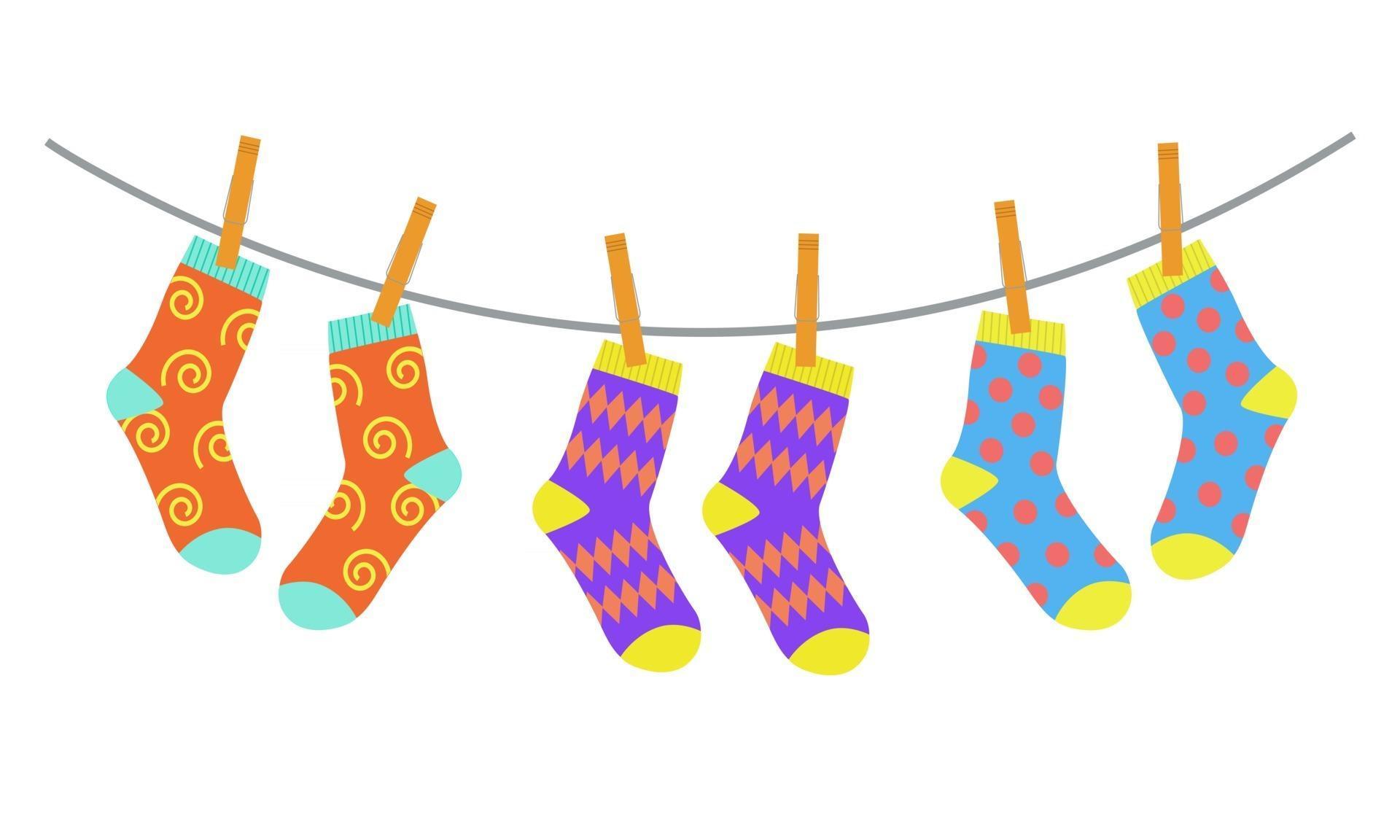 Three pairs of colorful children socks drying on the clothesline