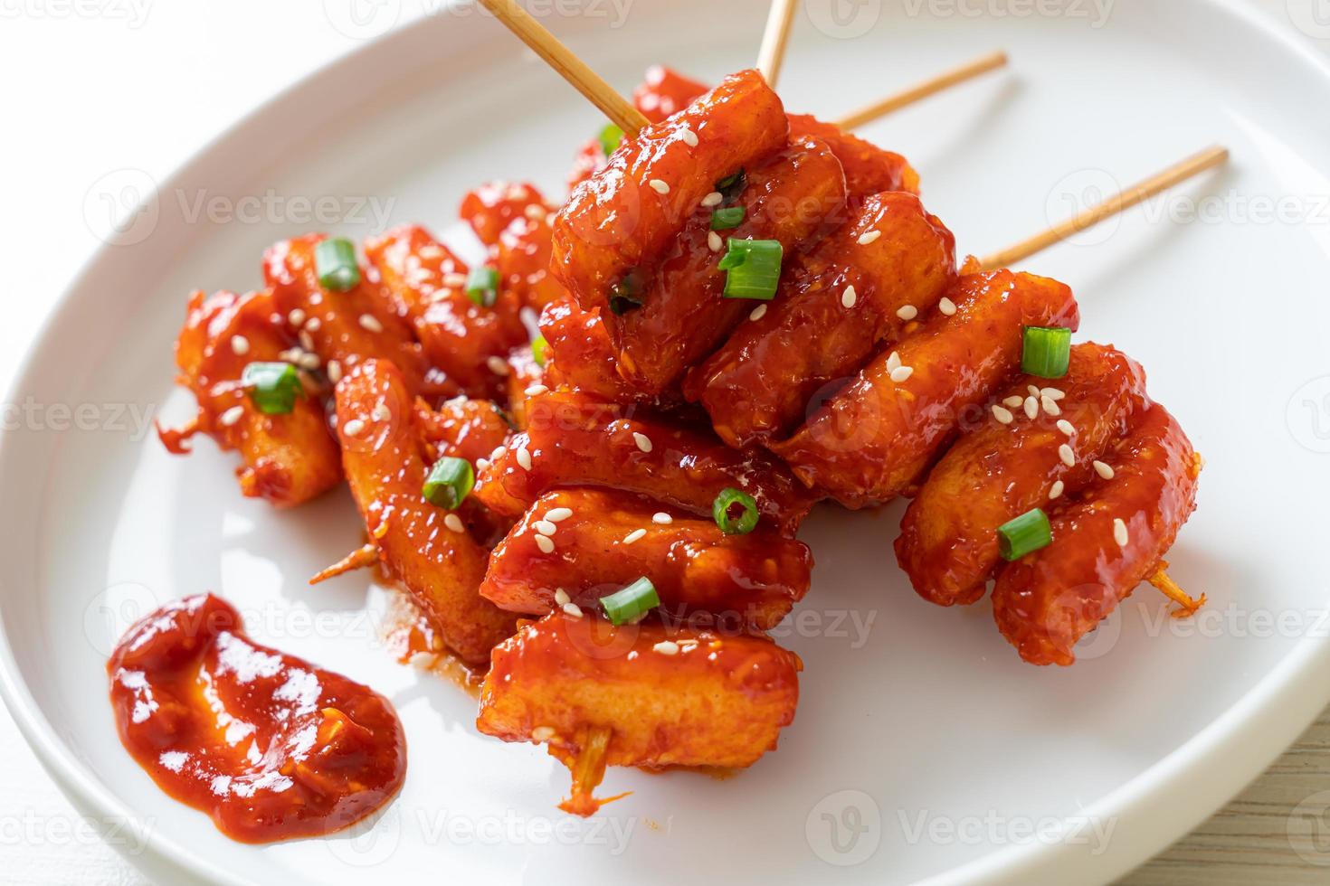 pastel de arroz coreano frito ensartado con salsa picante foto