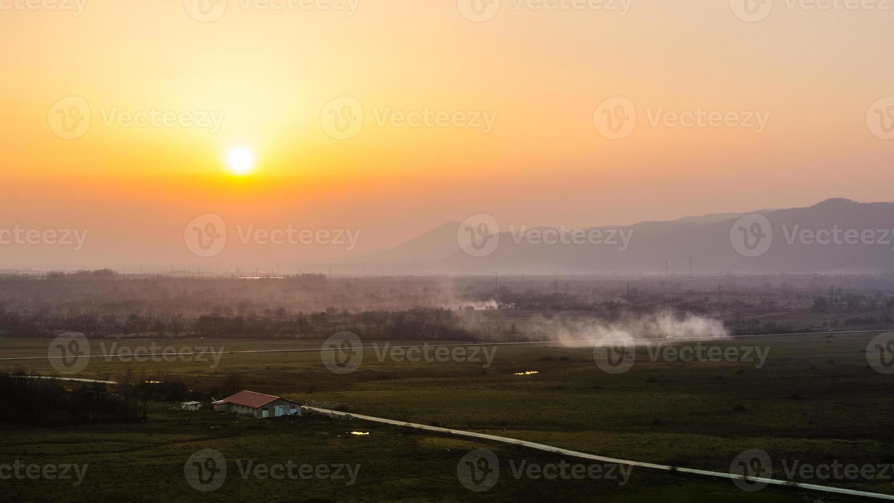 Sunset landscape orange sky and silhouettes of hills in the background photo