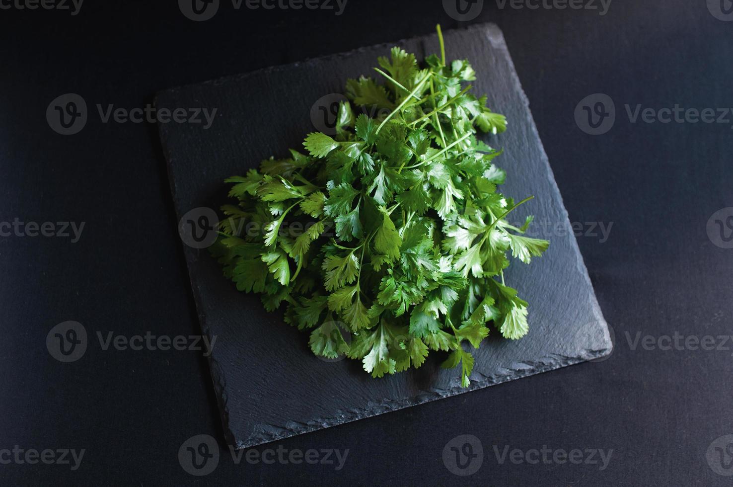 Fresh dill and parsley on a black board photo