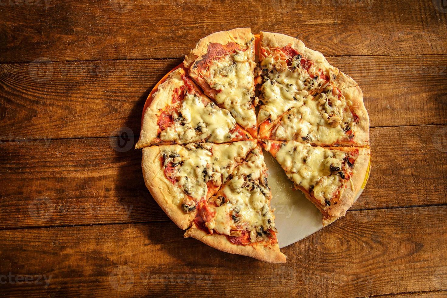 Pizza  lies on a wooden table photo