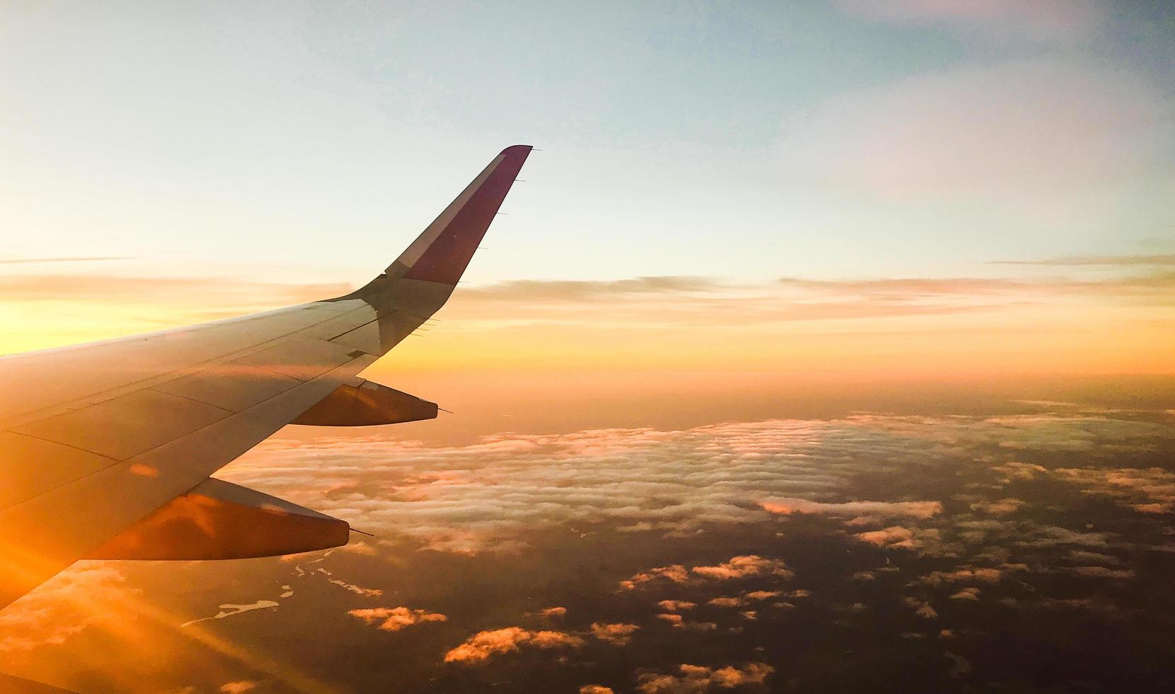 en vuelo de avión vista desde la ventana con un impresionante fondo de puesta de sol foto