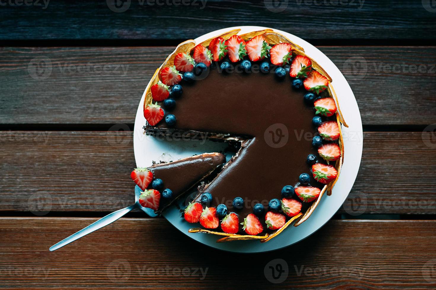 delicioso pastel de chocolate con bayas y glaseado, vista superior foto