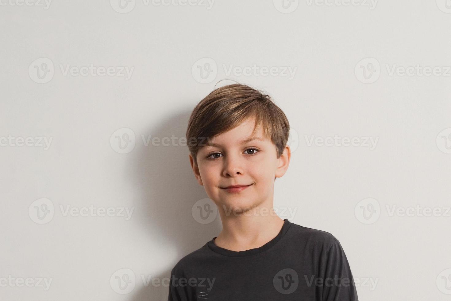 a closeup portrait of a smiling cute boy in a grey shirt photo