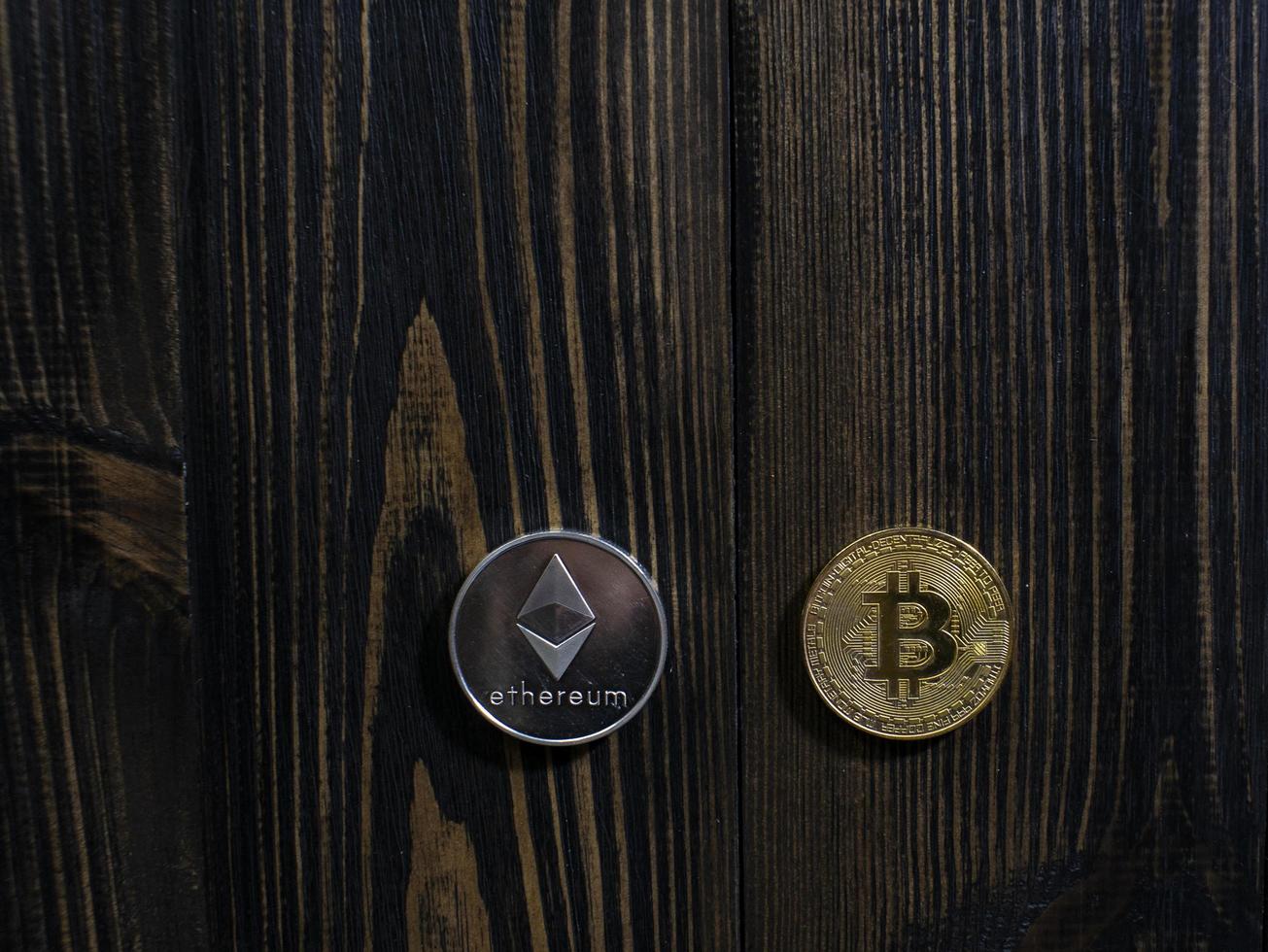 Bitcoin and Ethereum on a wooden background photo