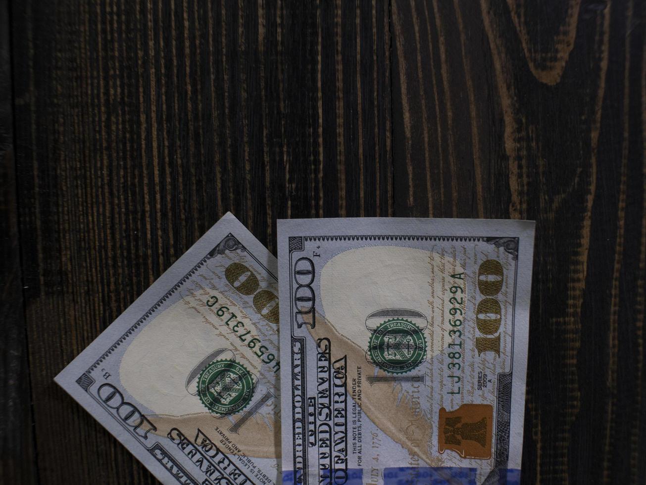 Two hundred dollars bills on a wooden background photo