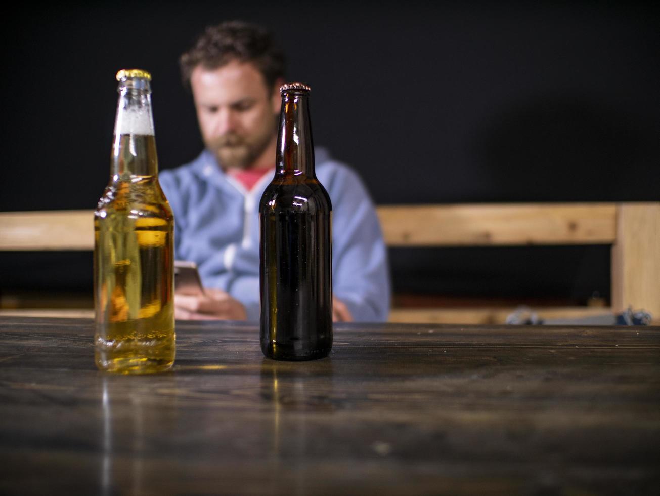 dos botellas de cerveza están de pie sobre la mesa foto