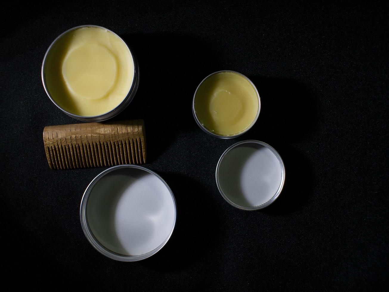 Beard and mustache wax and wooden comb on black background photo