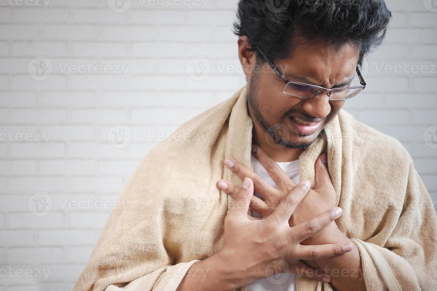 Mature man in blanket coughing while sited on bed photo