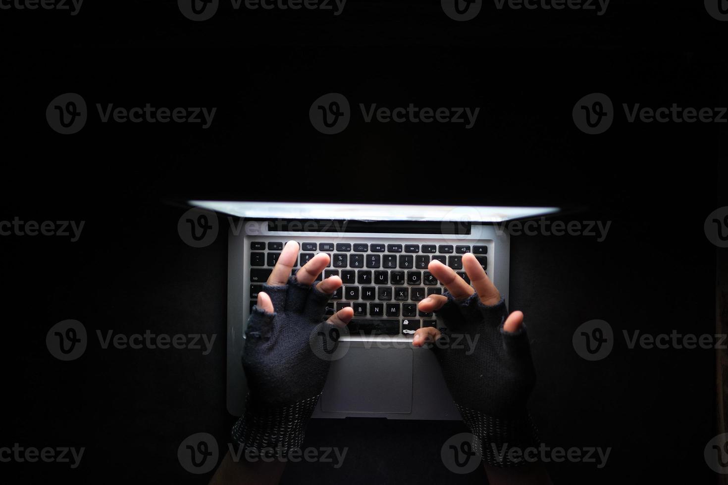 hacker hand stealing data from laptop top down photo
