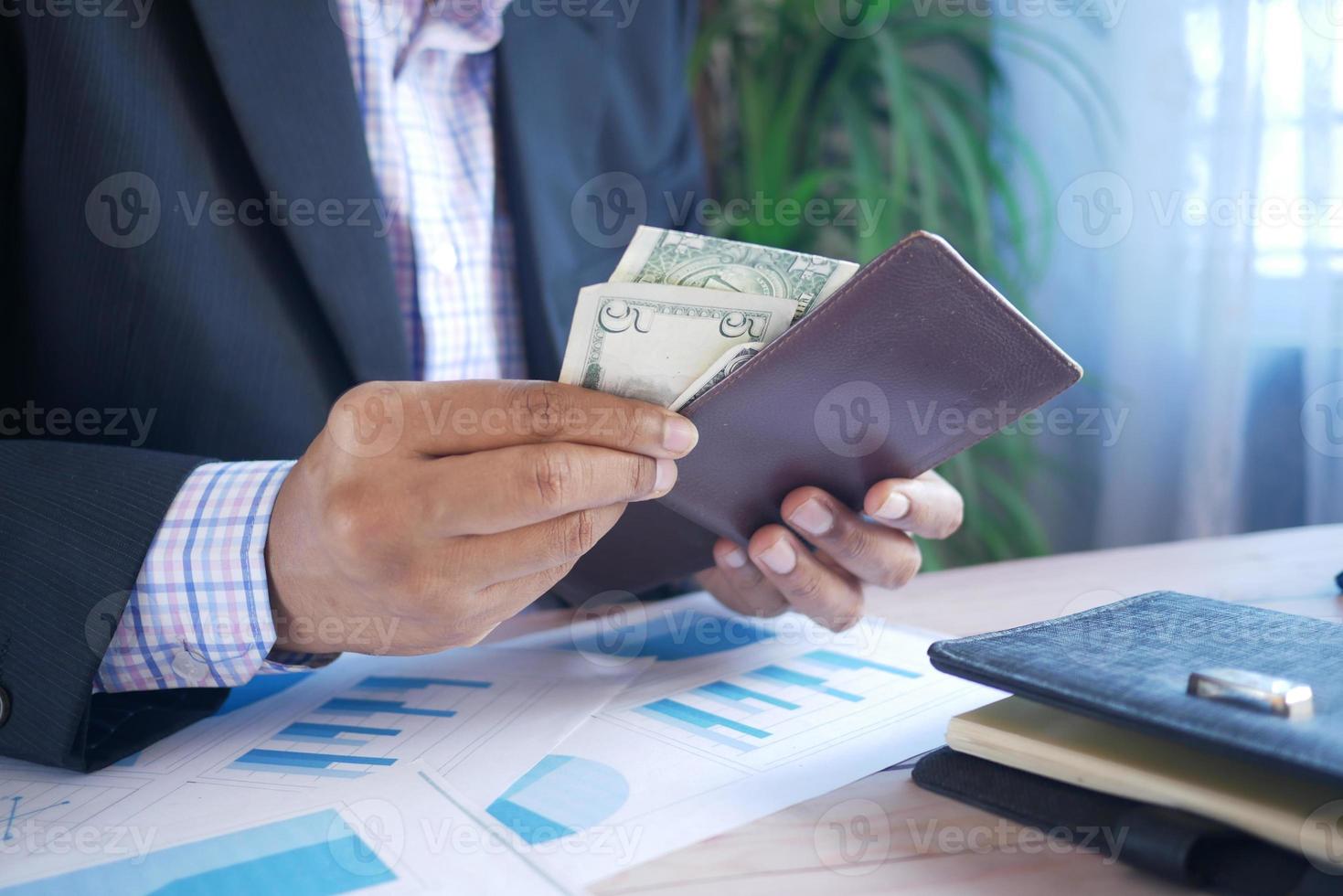 young businessman taking cash out from wallet photo