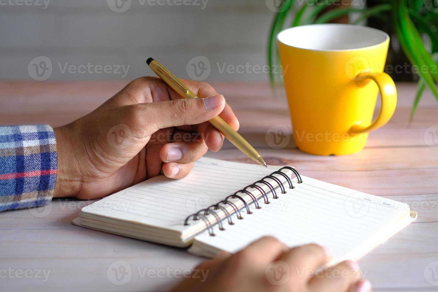 cerca de la mano del hombre escribiendo en el Bloc de notas. foto