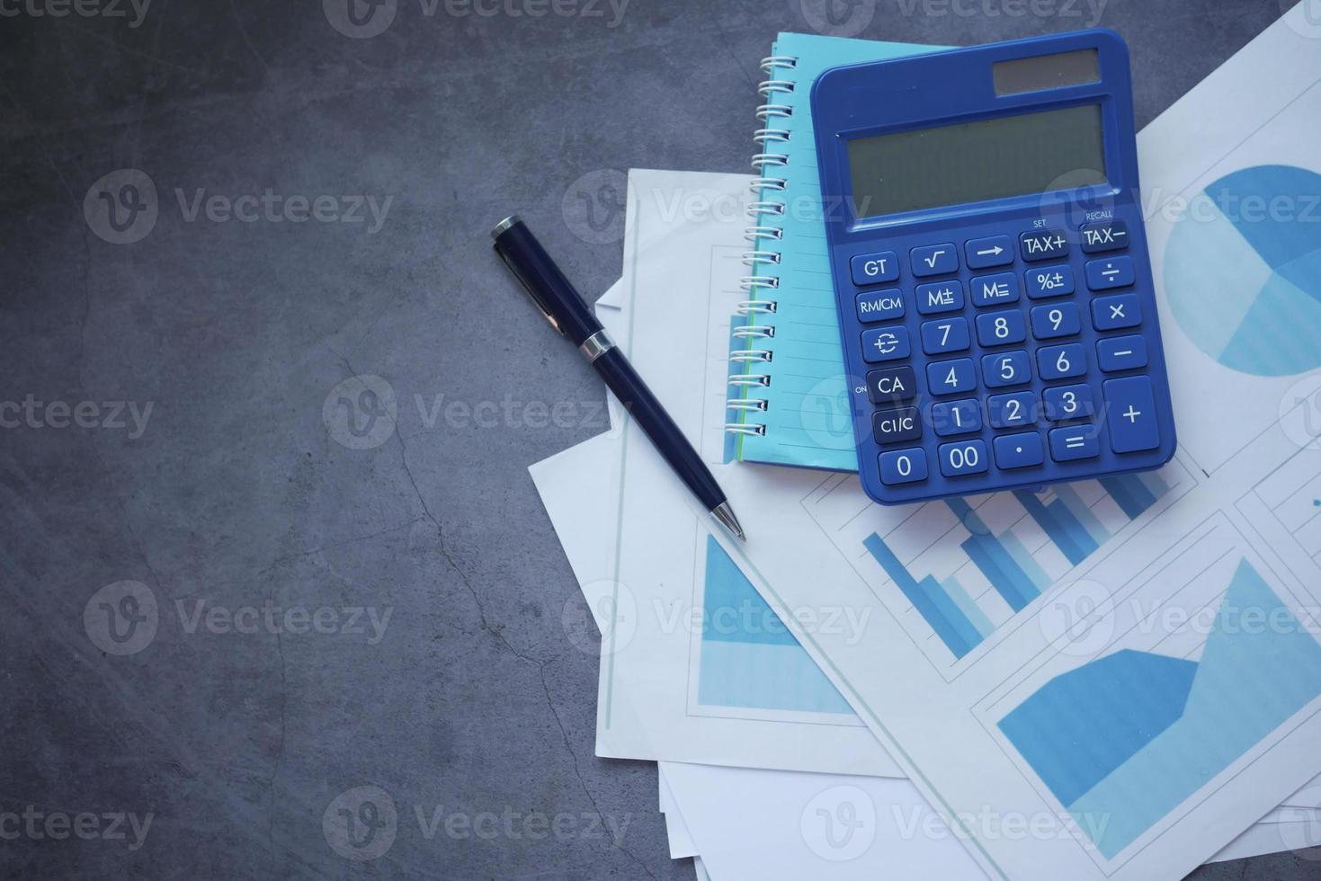 financial graph, calculator and notepad on black background photo