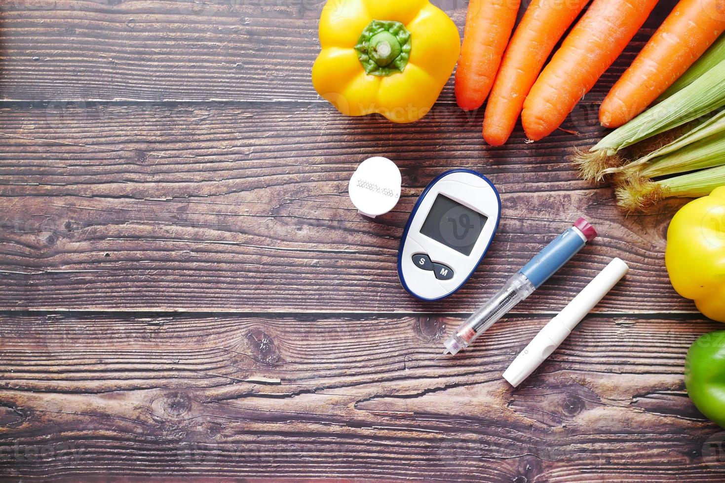 Herramientas de medición para diabéticos y verduras frescas en la mesa foto