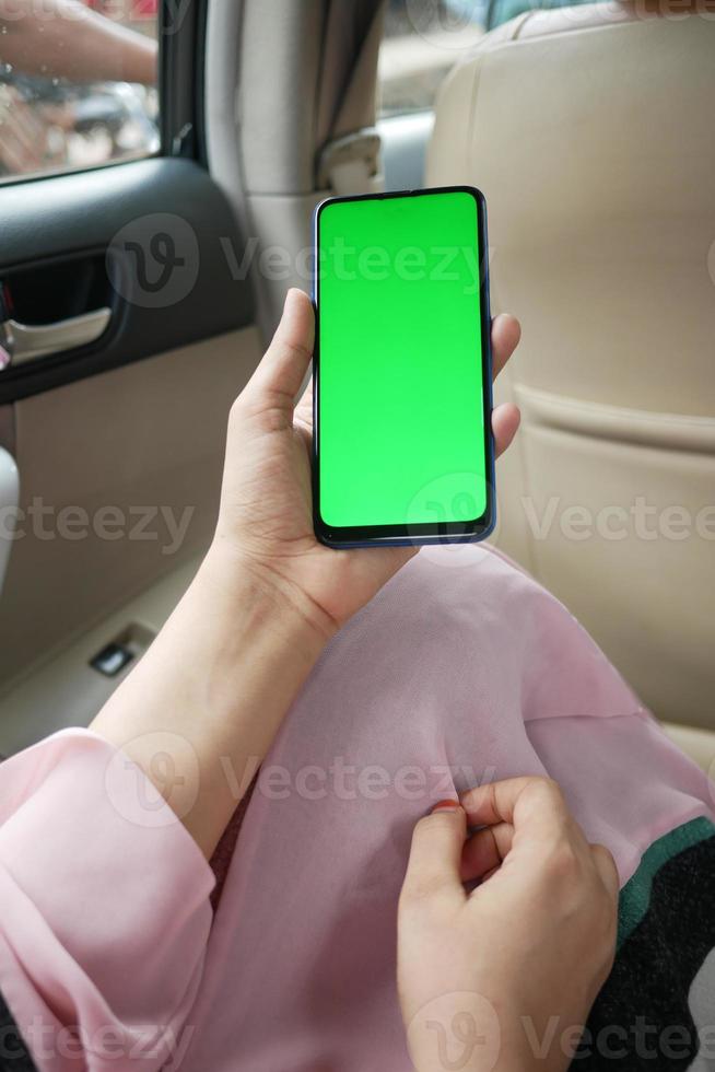 mano de mujer sosteniendo teléfono inteligente en un coche foto