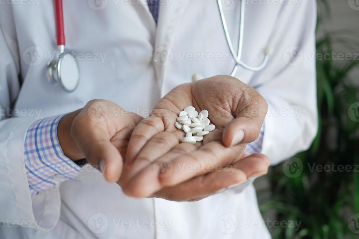 doctor holding medical pill on palm of hand photo