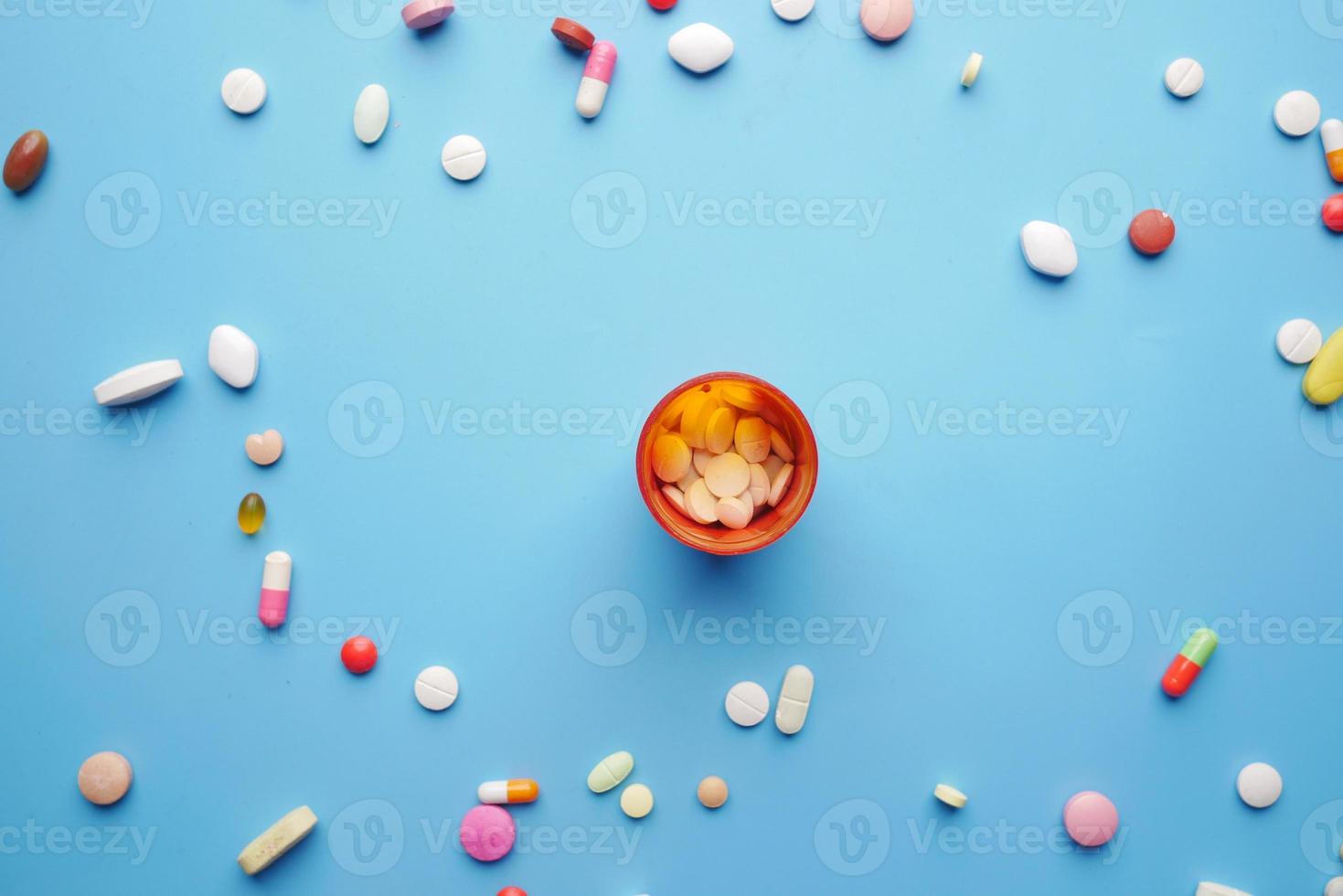 top view of many colorful pills and capsules on blue background photo