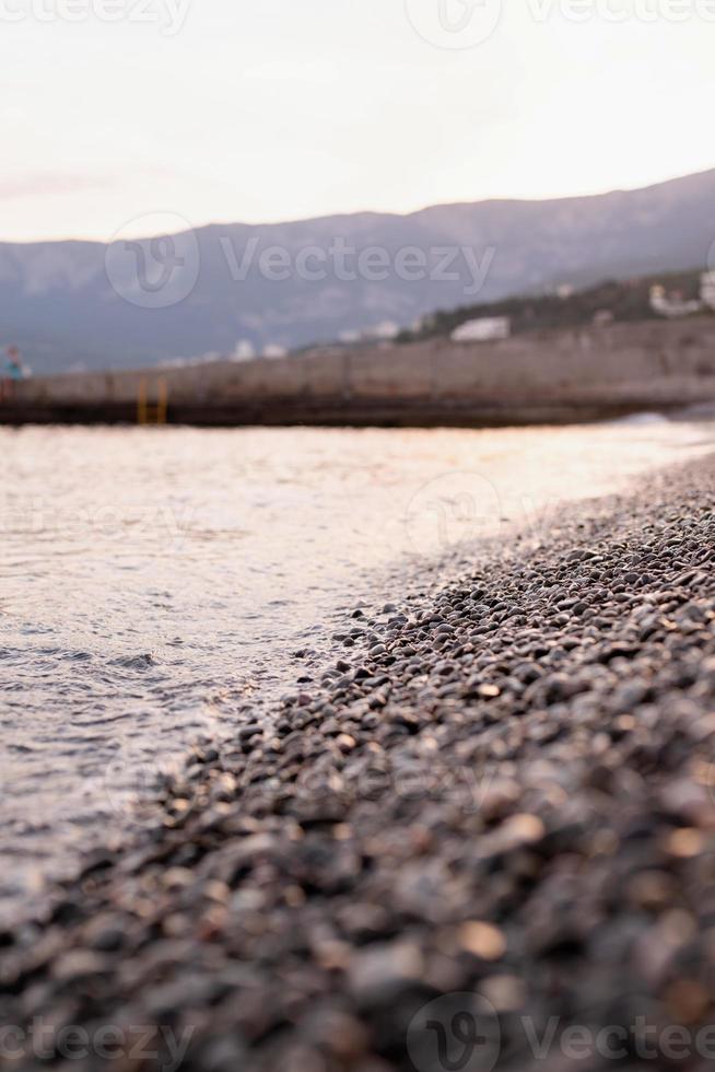 Playa de piedras de guijarros y el mar, fondo de naturaleza foto